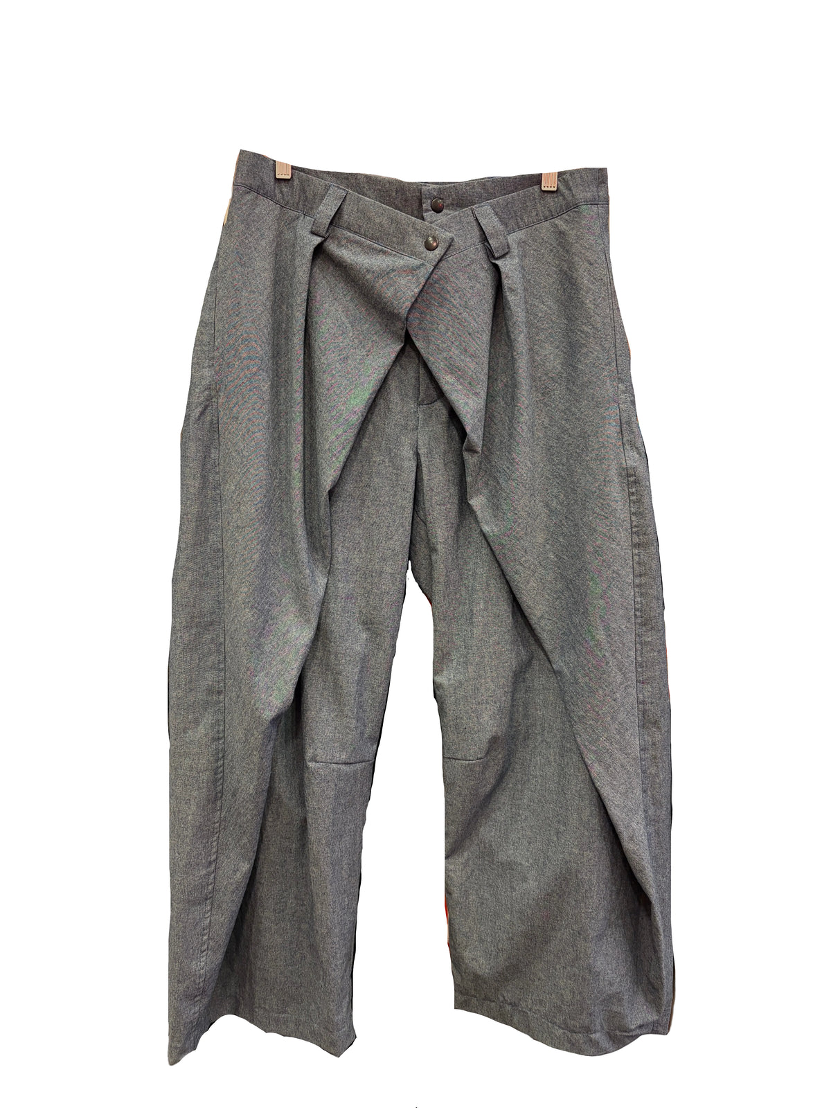 A pair of light blue chambrtay trousers with dramatic draped side panels.